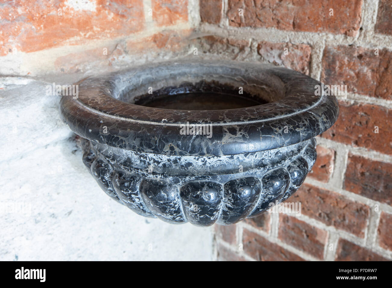 Alten heiligen Wasser font oder weihwasserbecken, schwarzer Stein Schiff, Detail. Dom in Gniezno, Polen Stockfoto