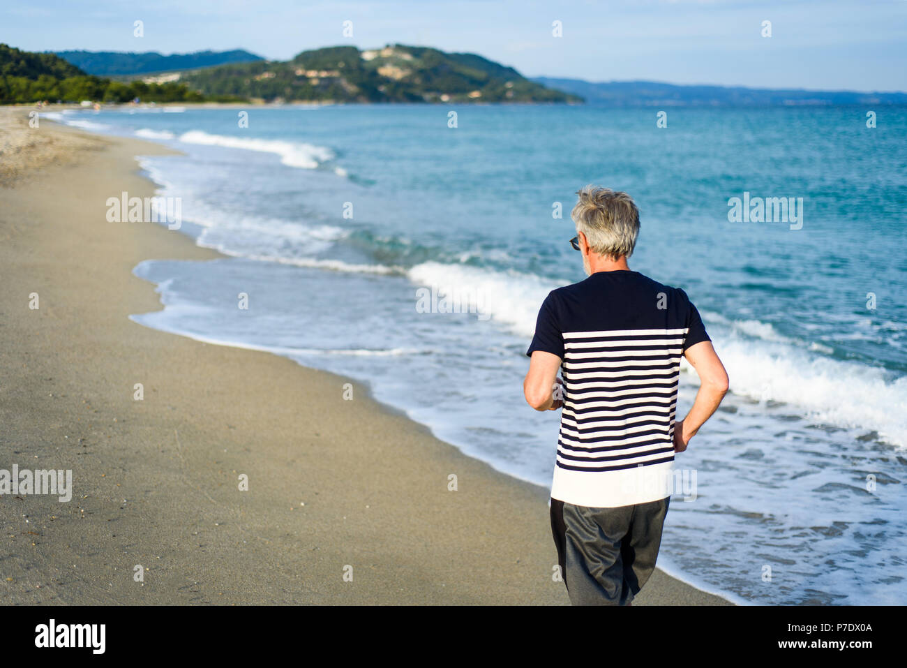 Älterer Mann laufen am Strand, aktiven Urlaub lifestyle Stockfoto