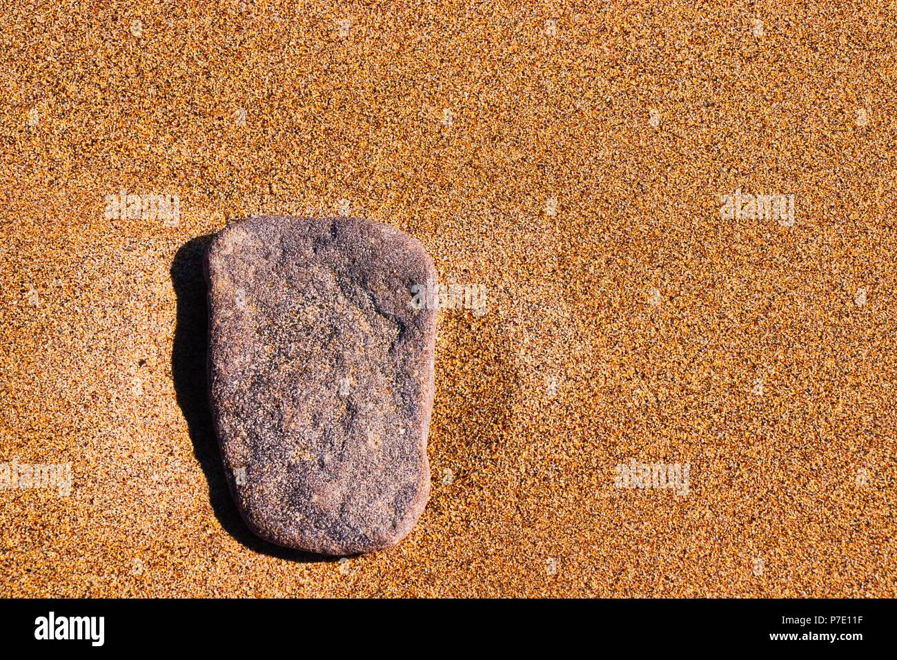 Flachen Stein auf orange Sand Stockfoto