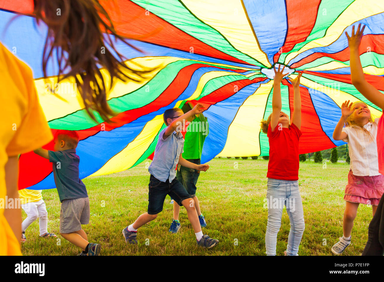 Unbegrenzte Freude unter Rainbow Fallschirm Stockfoto