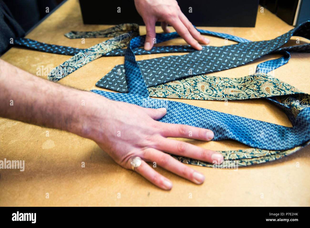 Kunden die Wahl einer Krawatte auf Schneider Tabelle, Detail der Hände Stockfoto