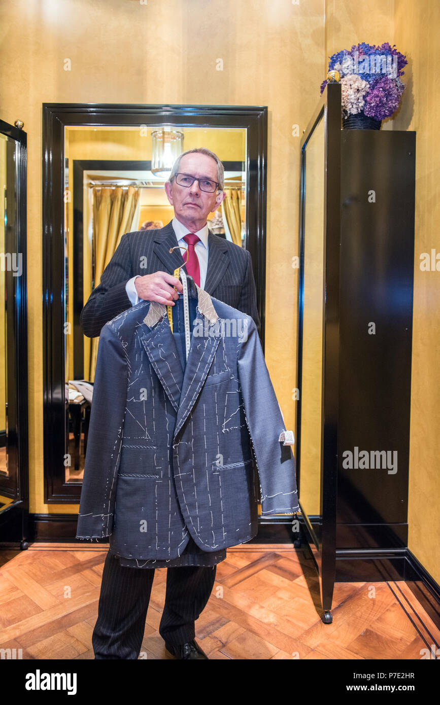 Tailor Holding unvollendete maßgeschneiderte Jacke in Schneider, Porträt Stockfoto