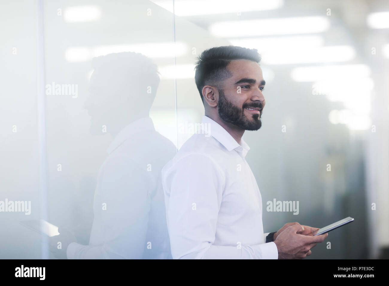 Junger Mann mit Handy im Büro Stockfoto