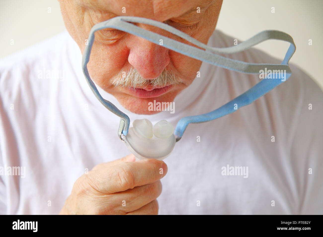 Nahaufnahme der ältere Mann mit den Kopfbedeckungen Teil einer kontinuierlichen positiven Atemwegsdruck Maschine für Schlafapnoe Stockfoto