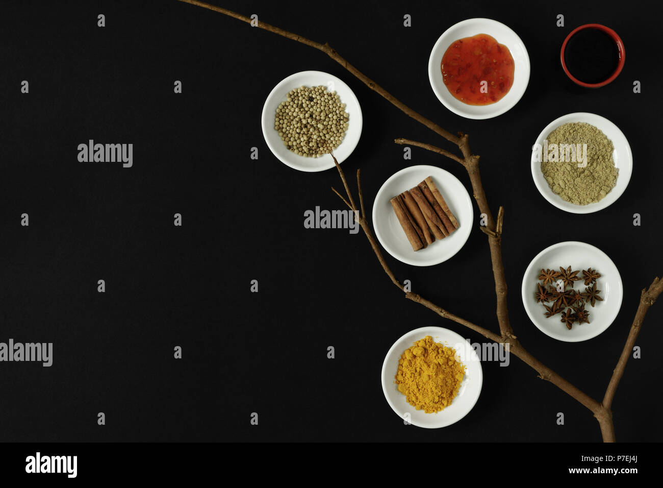 Asiatische Gewürze, Kräuter und Zutaten zum Kochen auf schwarzem Hintergrund. Stockfoto