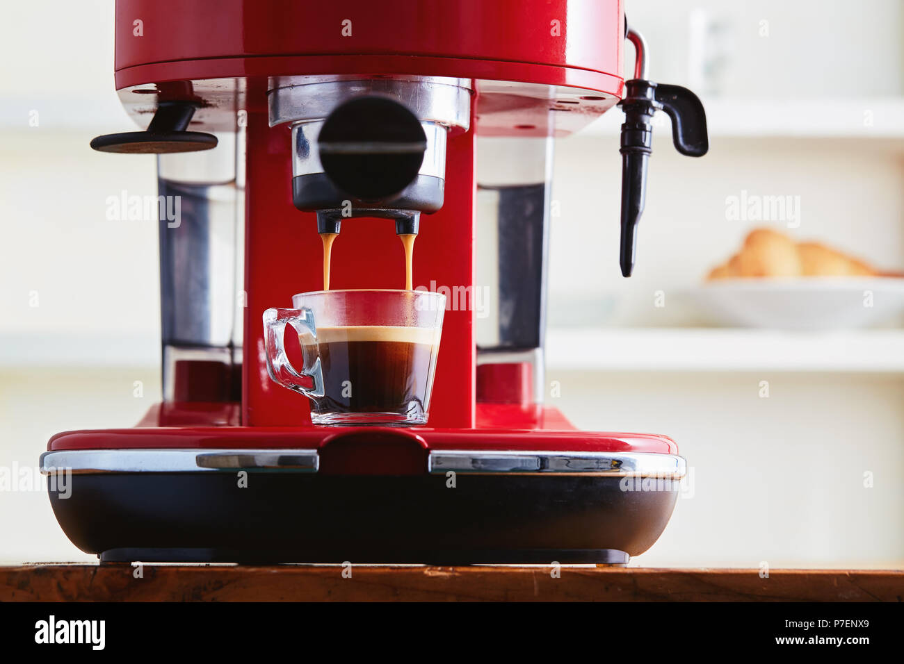 Einen frischen Kaffee aus einer Kaffeemaschine Espressomaschine. Die Espresso in Glas transparent Kaffeetasse. Stockfoto