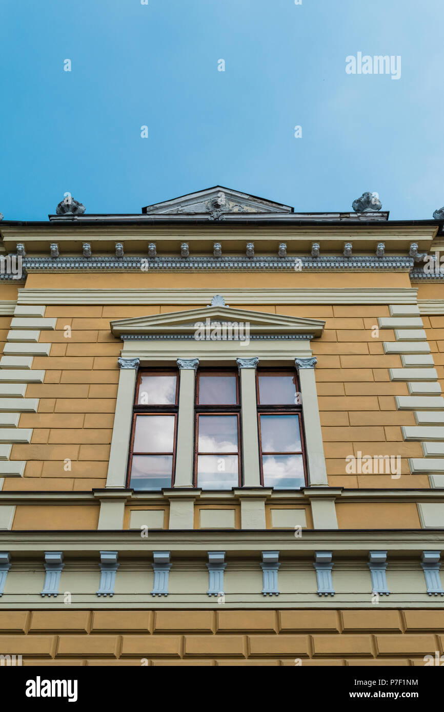 Ein Fenster mit bas-relief auf der Fassade. Dekorative Fensterrahmen. Stockfoto