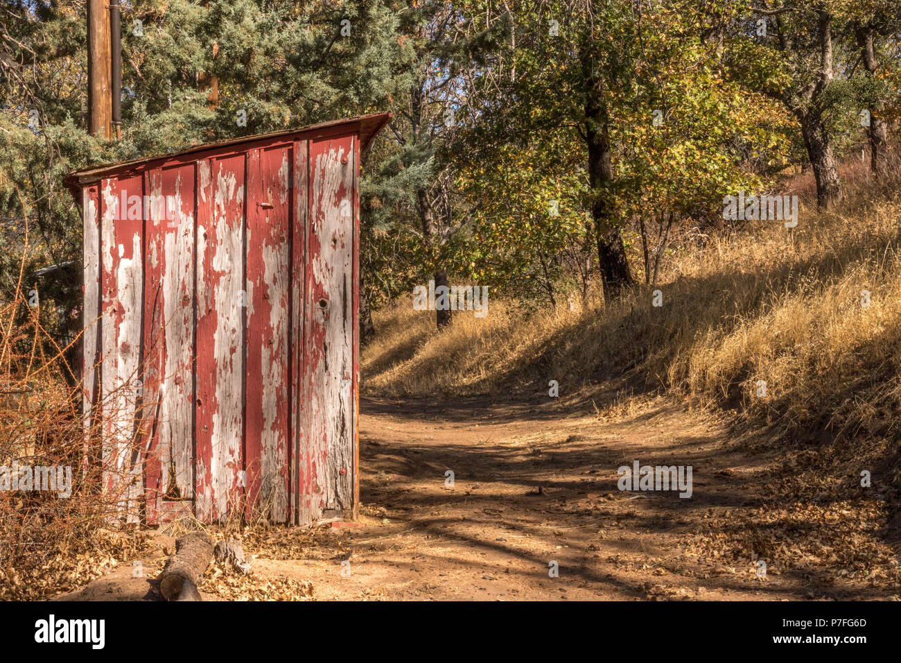 Alte, Peeling roter Farbe auf kleinen, Holz vintage, aufbauend auf den ländlichen Weg im Herbst Stockfoto