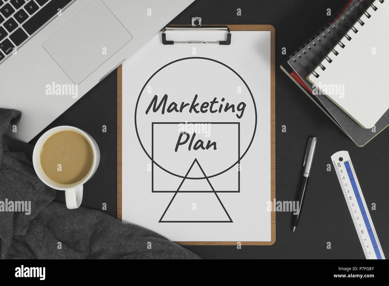 Marketing Plan auf weißem Papier mit Laptop Computer abgelegt. Business und Marketing Konzept. Stockfoto