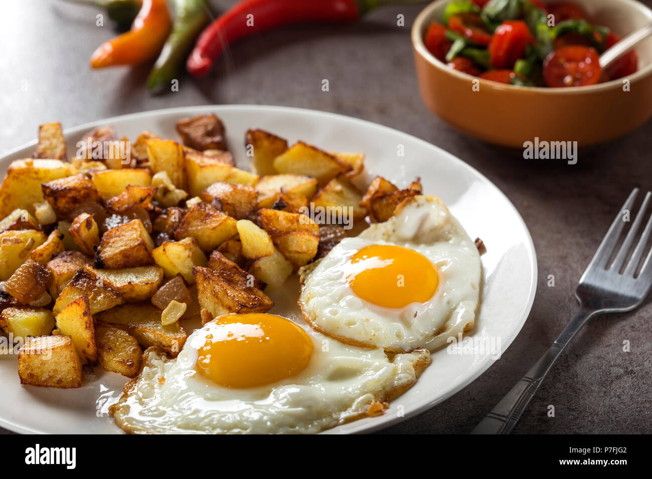 Eier und Pommes Frites mit kleinen Stücken des fettes Schwein Fleisch, Zwiebel und Knoblauch auf Platte Stockfoto