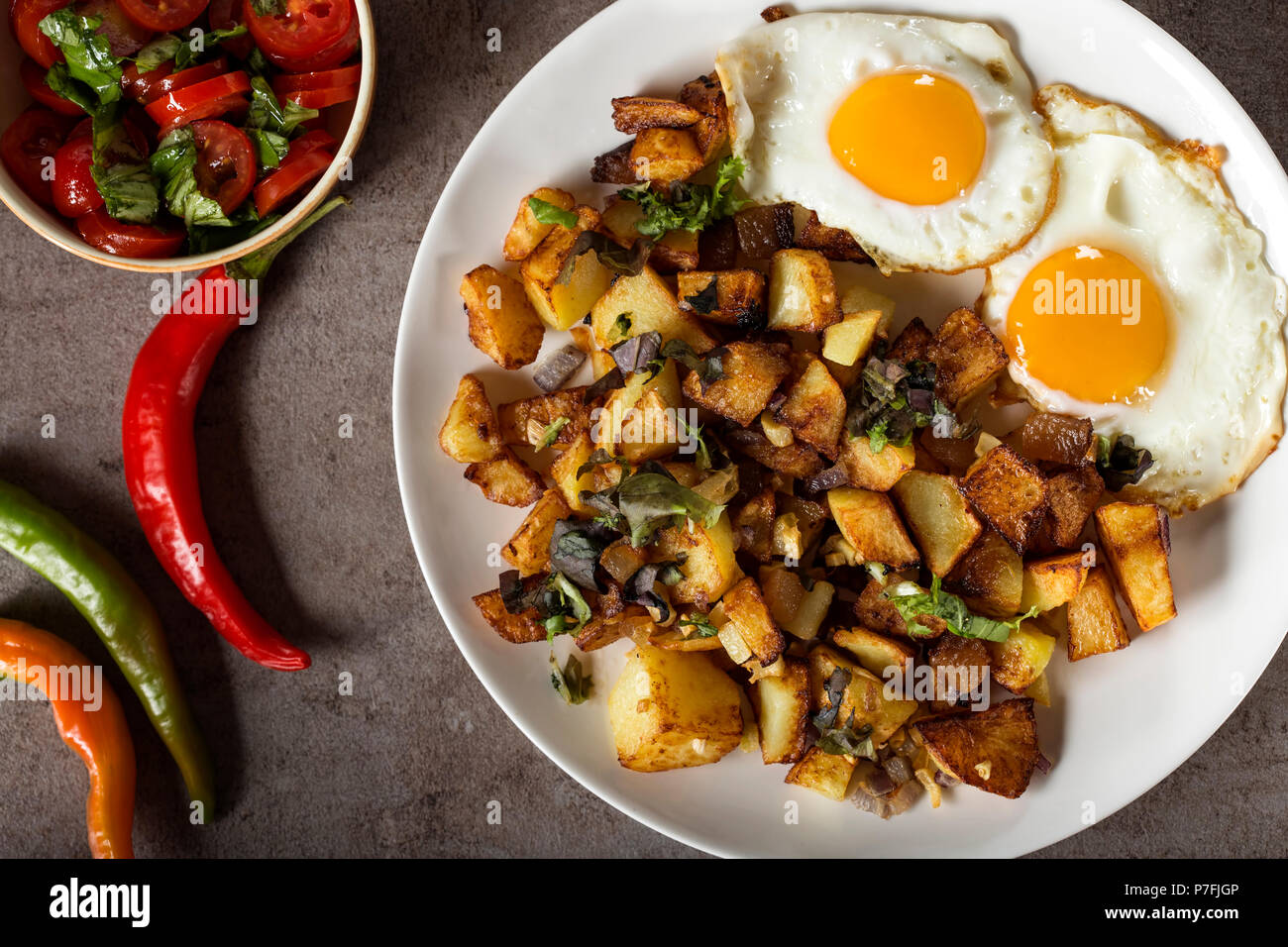 Eier und Pommes Frites mit kleinen Stücken des fettes Schwein Fleisch, Zwiebel und Knoblauch auf dem Teller - Ansicht von oben Stockfoto