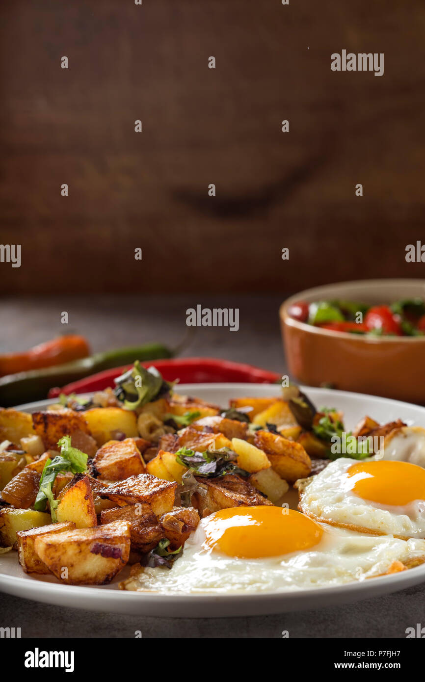 Eier und Pommes Frites mit kleinen Stücken des fettes Schwein Fleisch, Zwiebel und Knoblauch auf Platte Stockfoto