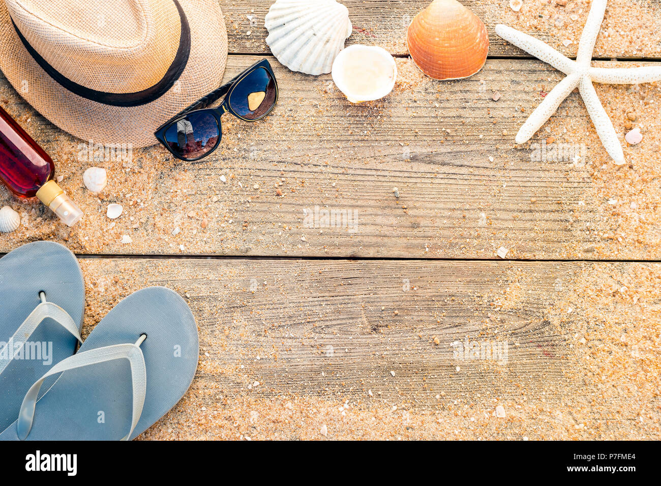 Sommer Accessoires wie Hut, Muscheln und Sonnenbrille auf Holz- und Sandy Hintergrund Stockfoto