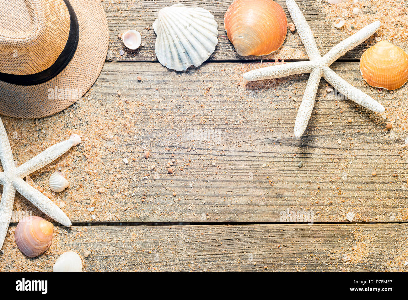 Sommer Accessoires wie Hut, Muscheln und Sonnenbrille auf Holz- und Sandy Hintergrund Stockfoto