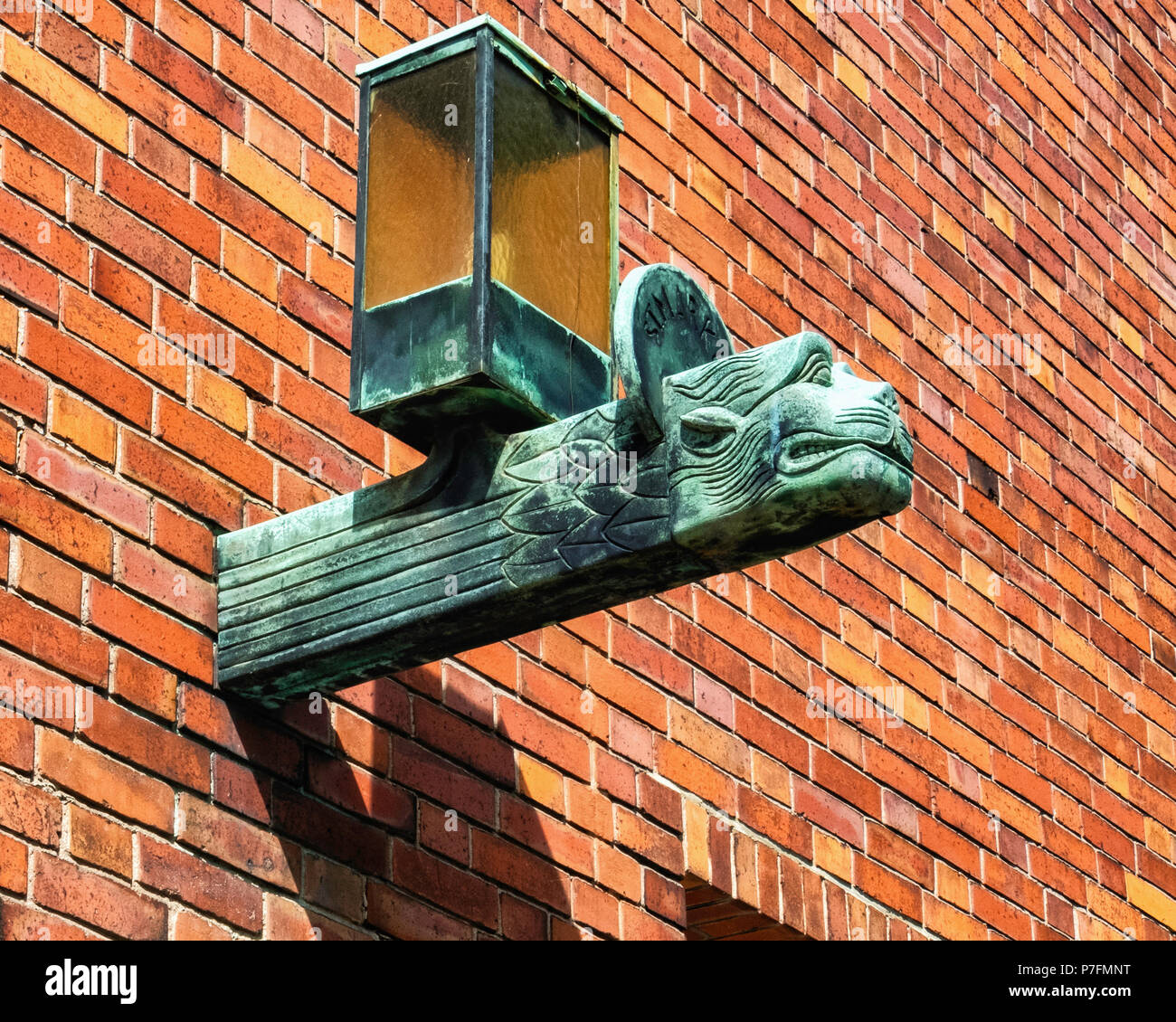 Berlin-Dahlem.Dorf. Saint Bernard Katholische Kirche. Gebäude Licht Detail - Lion's Head ist das Symbol des Evangelisten Markus. Bronze Lampe Stockfoto