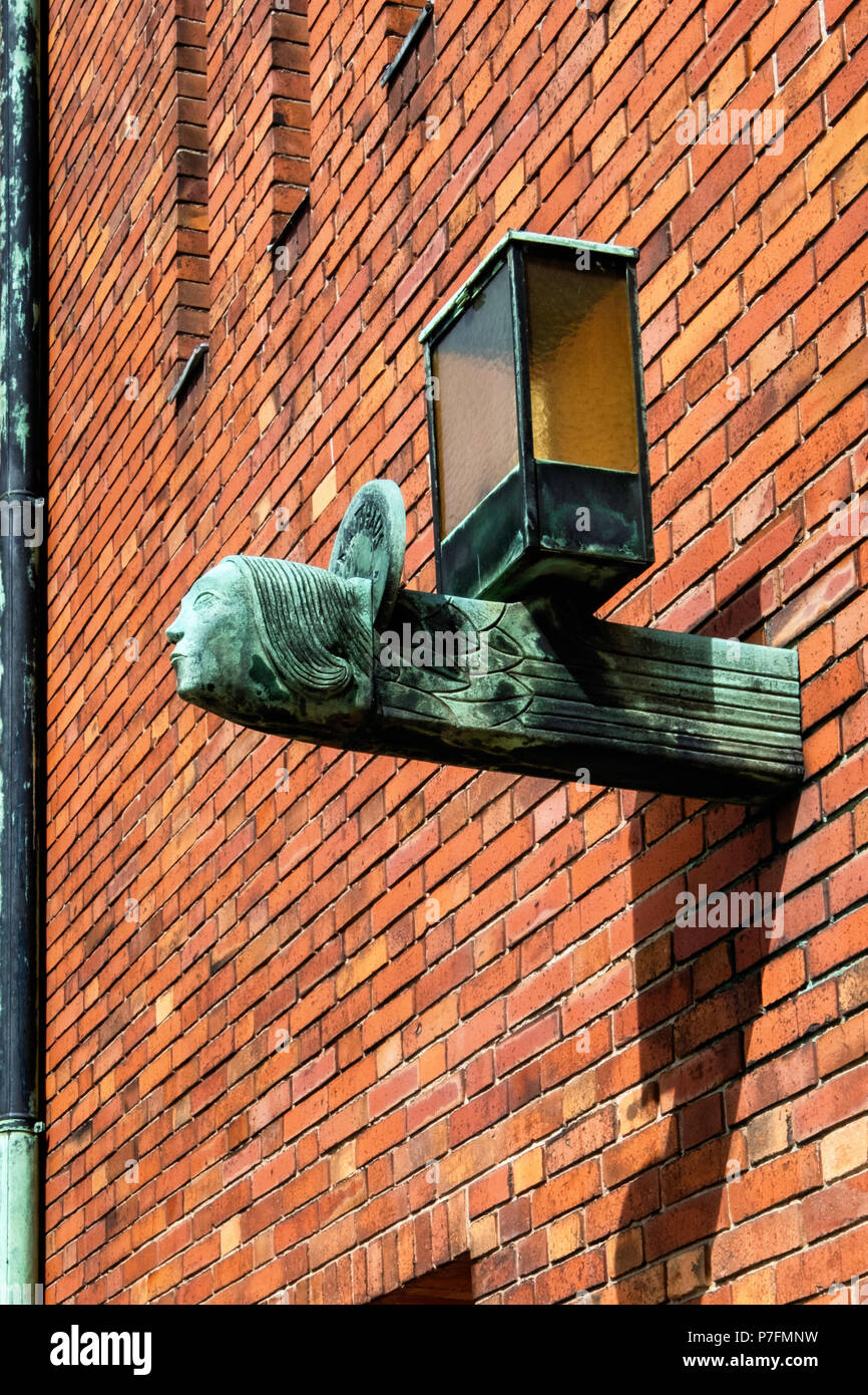 Berlin-Dahlem.Dorf. Saint Bernard Katholische Kirche. Backsteingebäude & Licht Detail - Prunkvolle bronze Lampe Stockfoto