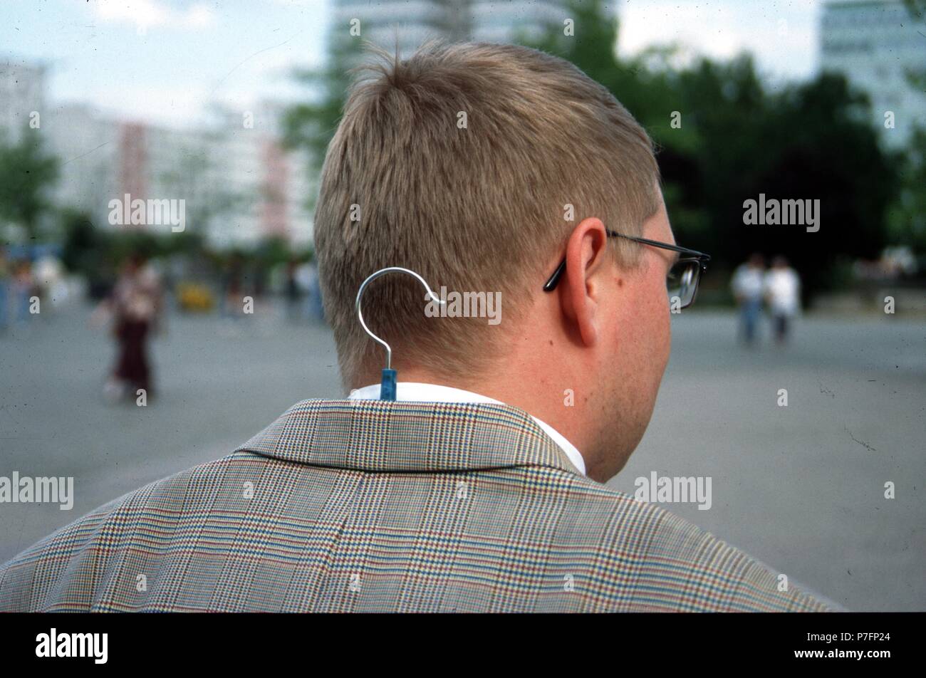 Mann mit Kleiderbügel unter Jacke, Berlin, Deutschland Stockfoto