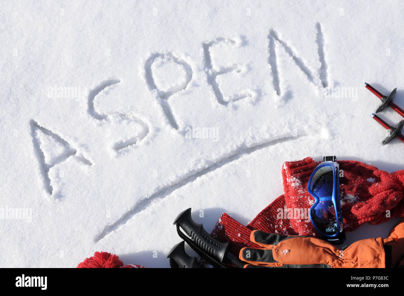 Das Wort Aspen im Schnee mit Ski Stöcke und Kleidung geschrieben. Stockfoto