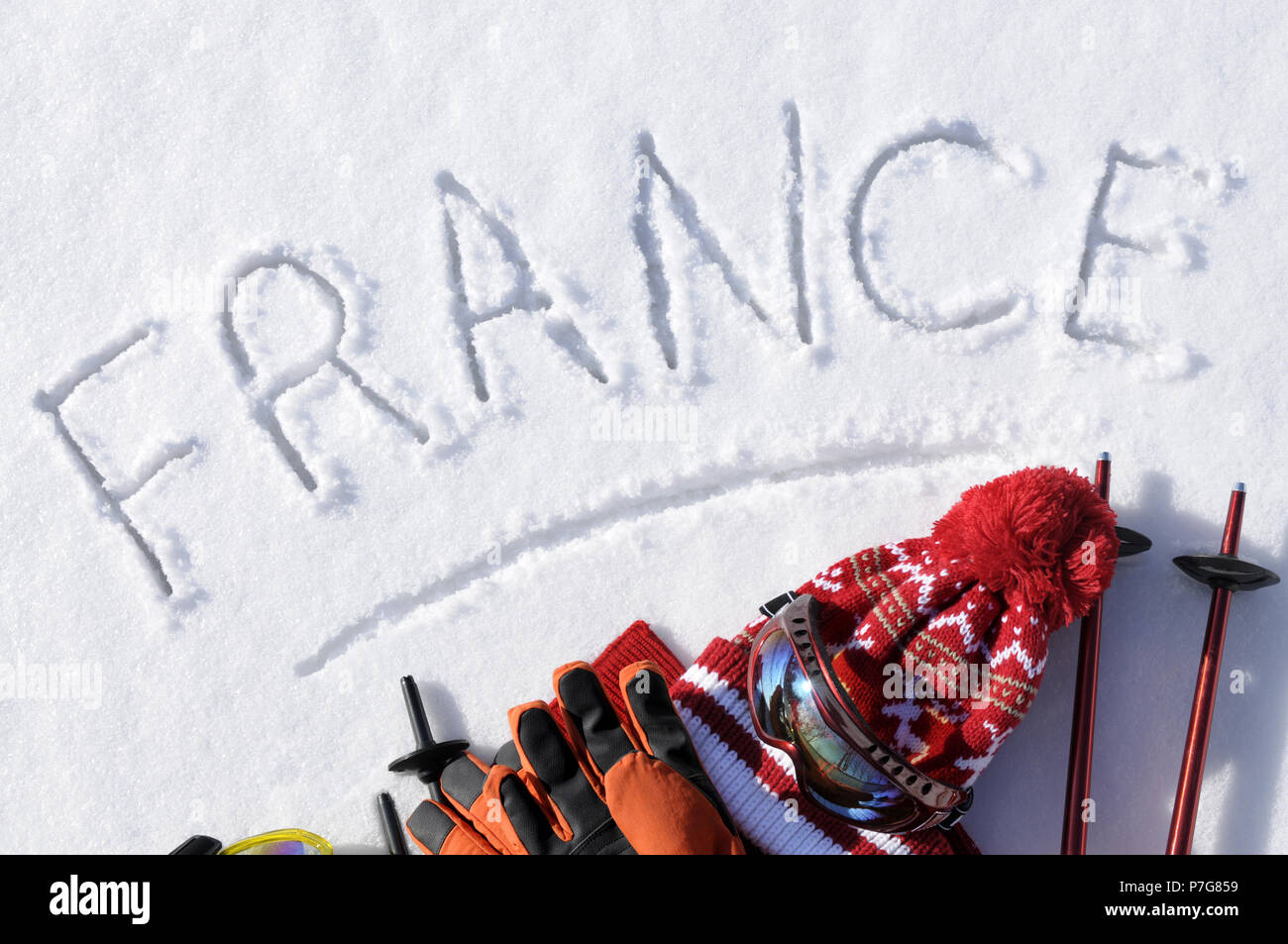 Das Wort Frankreich im Schnee mit Ski Stöcke, Schutzbrille und Hüte geschrieben. Stockfoto