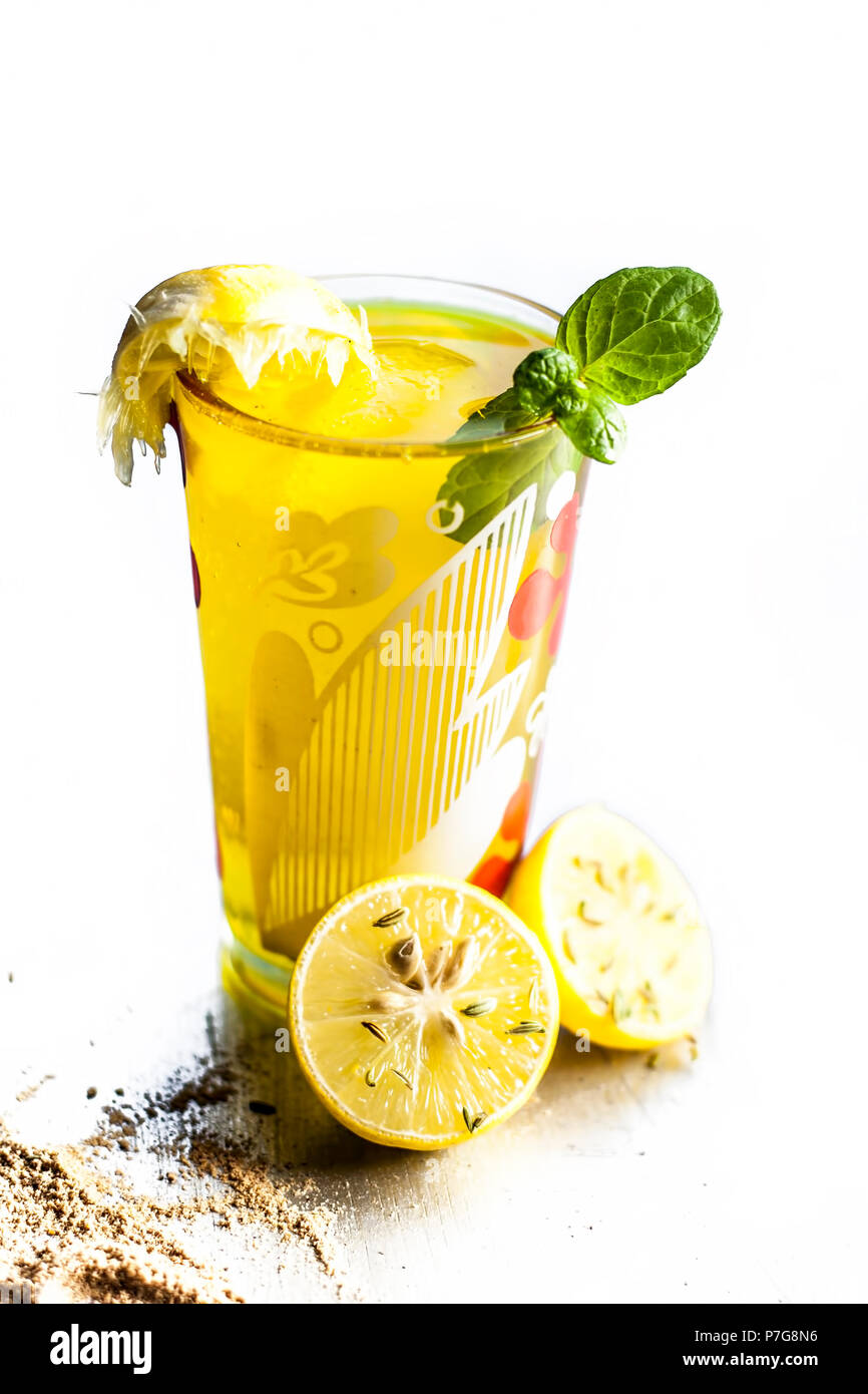 Nahaufnahme des indischen beliebtesten Sommerdrink Nimbu Pani oder Nimbo sarbat, Limonade in ein durchsichtiges Glas mit Salz und schwarzem Pfeffer. Auf einem weißen Isoliert Stockfoto
