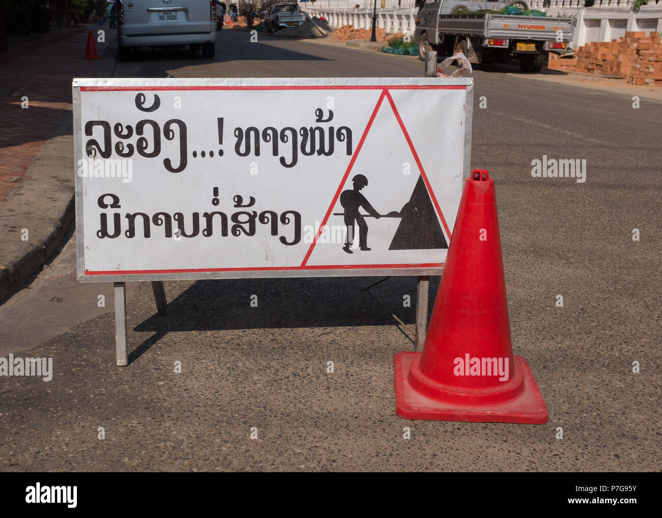 Männer an der Arbeit Schild mit leitkegel in Vientiane, Laos, Asien. Stockfoto