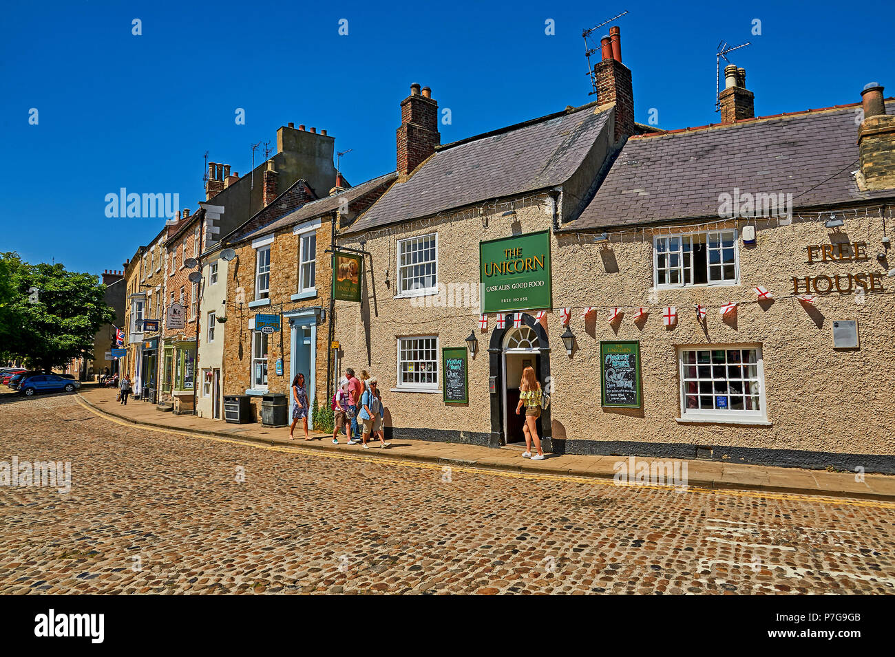 Das Einhorn Public House und verzierten Gebäuden Linie einer kopfsteingepflasterten Straße im Norden Yorkshire Markt Stadt Richmond. Stockfoto