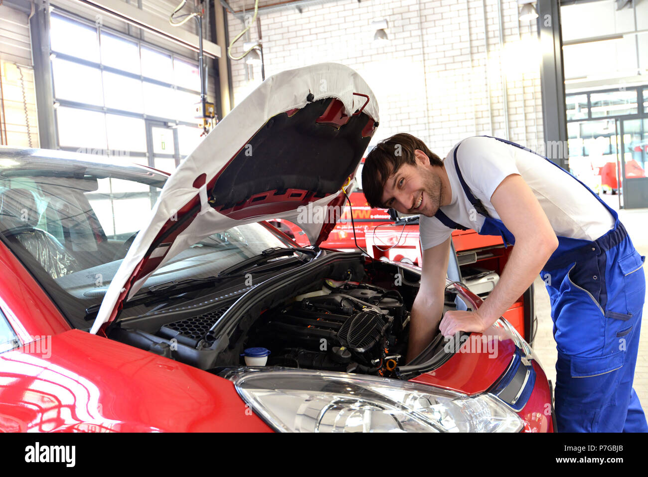 Mechaniker arbeitet an den Motor eines Fahrzeugs in der Werkstatt - Wartung und Kundendienst Stockfoto