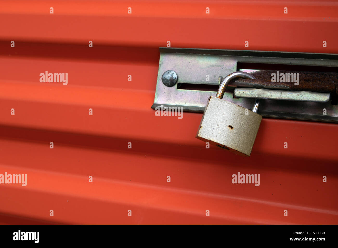 Schloss auf eine orange Self Storage Unit Tür. Stockfoto