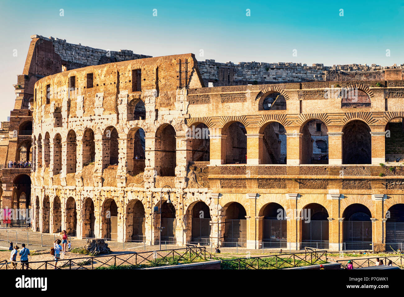 Rom, Italien, 30. Juni 2018: Blick auf das Kolosseum an einem Sommerabend mit Touristen, die die Schönheiten Roms durch die Fotos genießen. Stockfoto