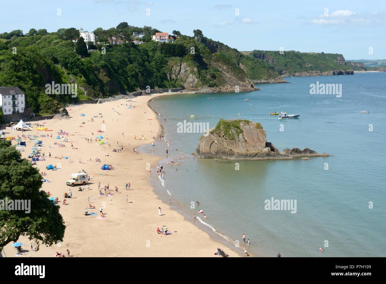 Menschen, die Touristen genießen den Sommer Sonnenschein om Tenby North Beach Pembrokeshire Wales Cymru GROSSBRITANNIEN Stockfoto