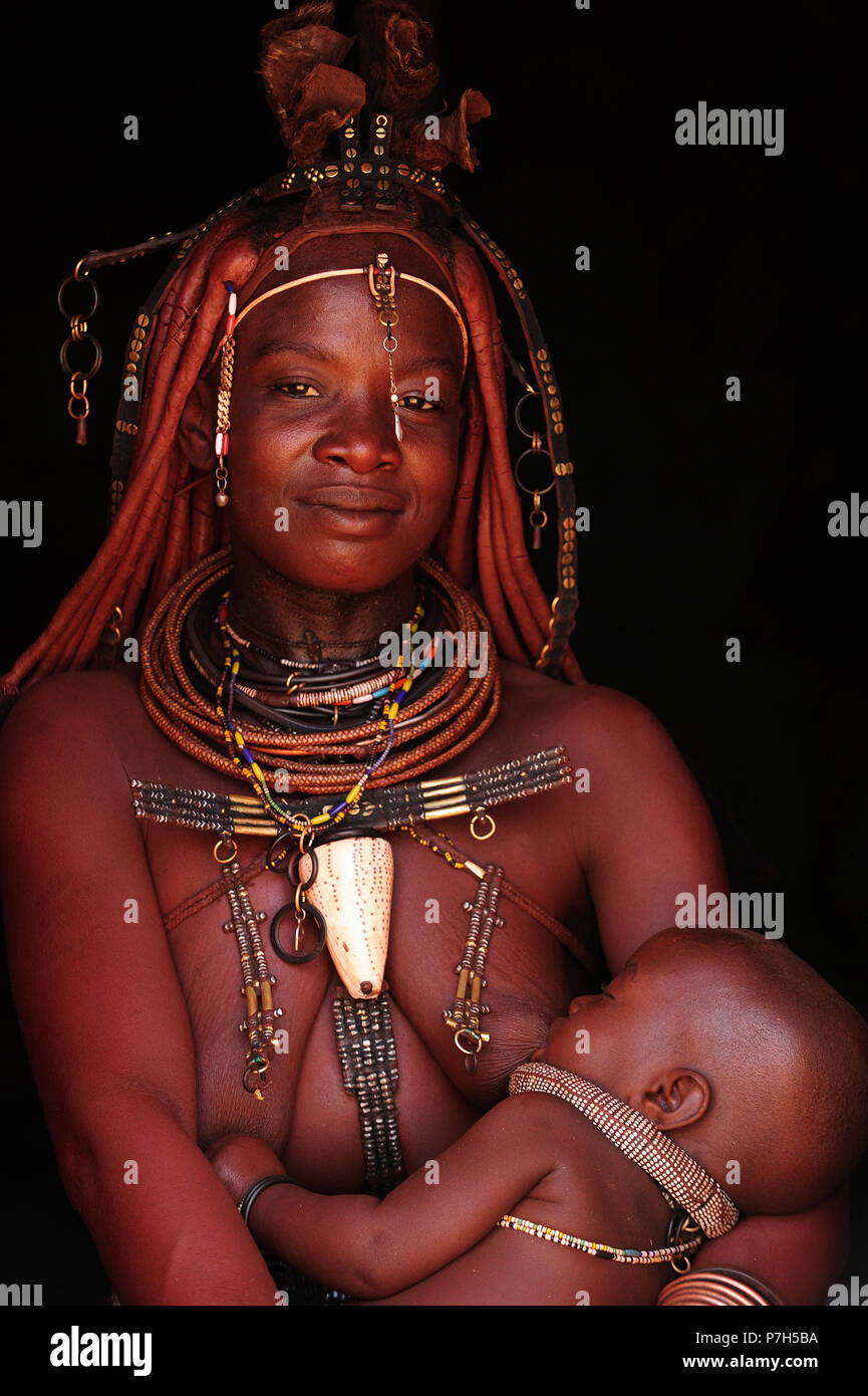 Verheiratete Frau Himba ihr Baby stillen, Kunene, Kaokoveld, Namibia Stockfoto