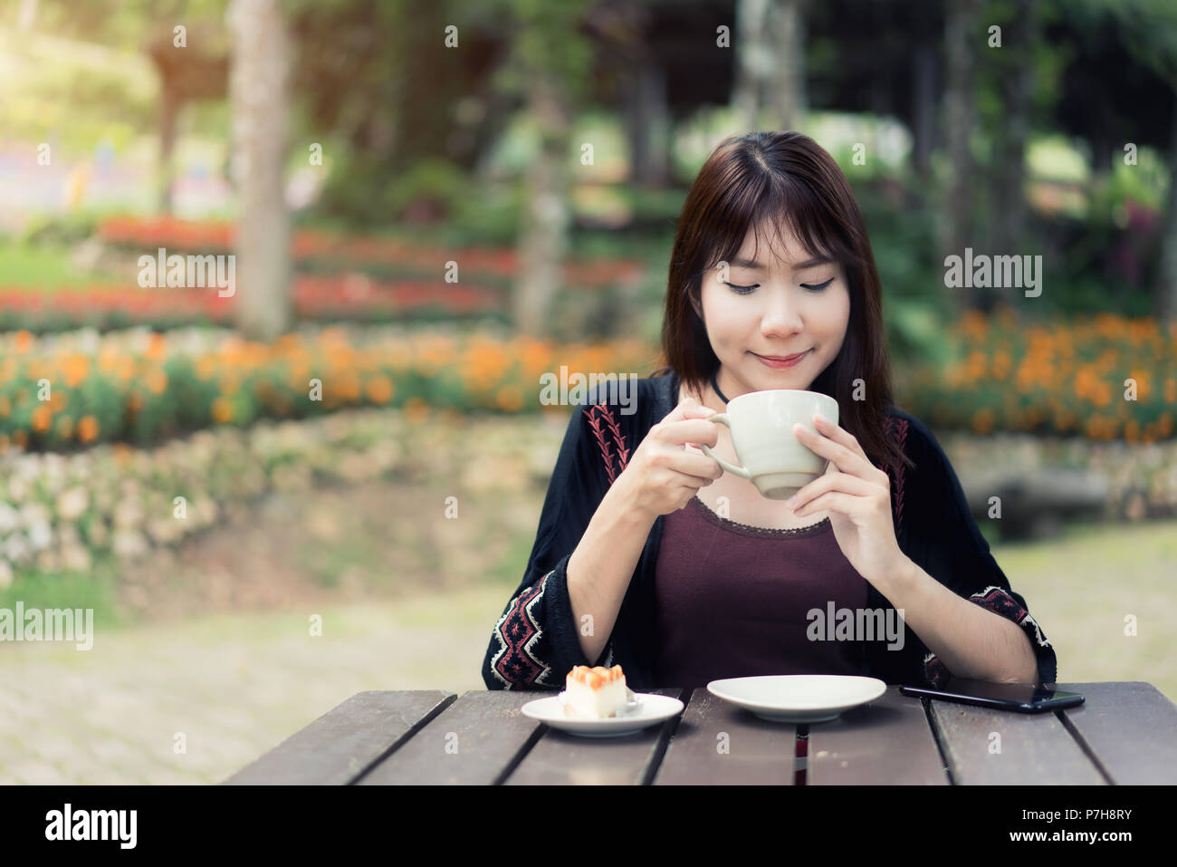 Asiatische Frauen entspannt zu Hause Garten mit einer Tasse Kaffee und Gefühl zu aktualisieren. Stockfoto