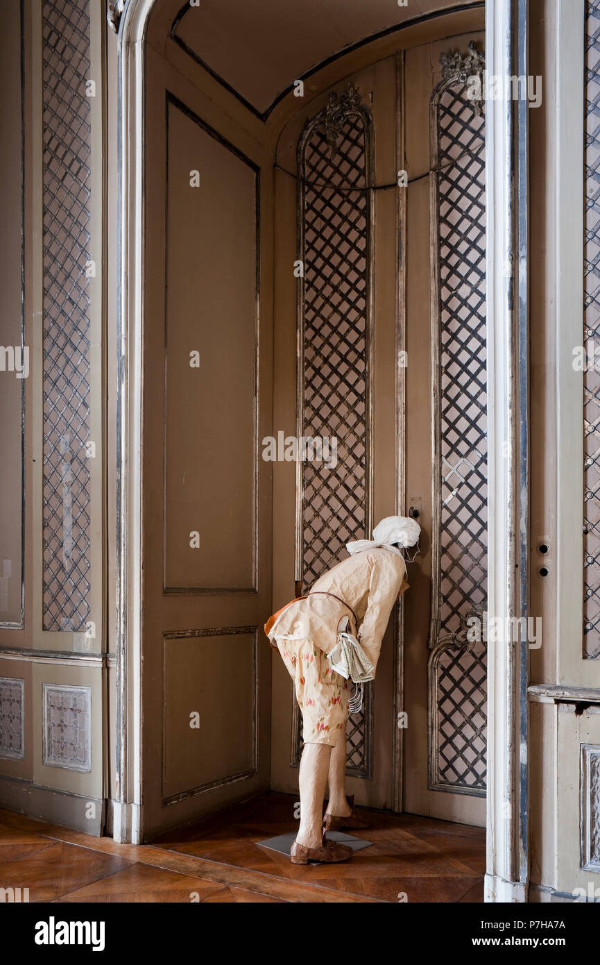 Mannequin tragen Papier im Stil des 18. Jahrhunderts Kleidung blickt durch Schlüsselloch Stockfoto