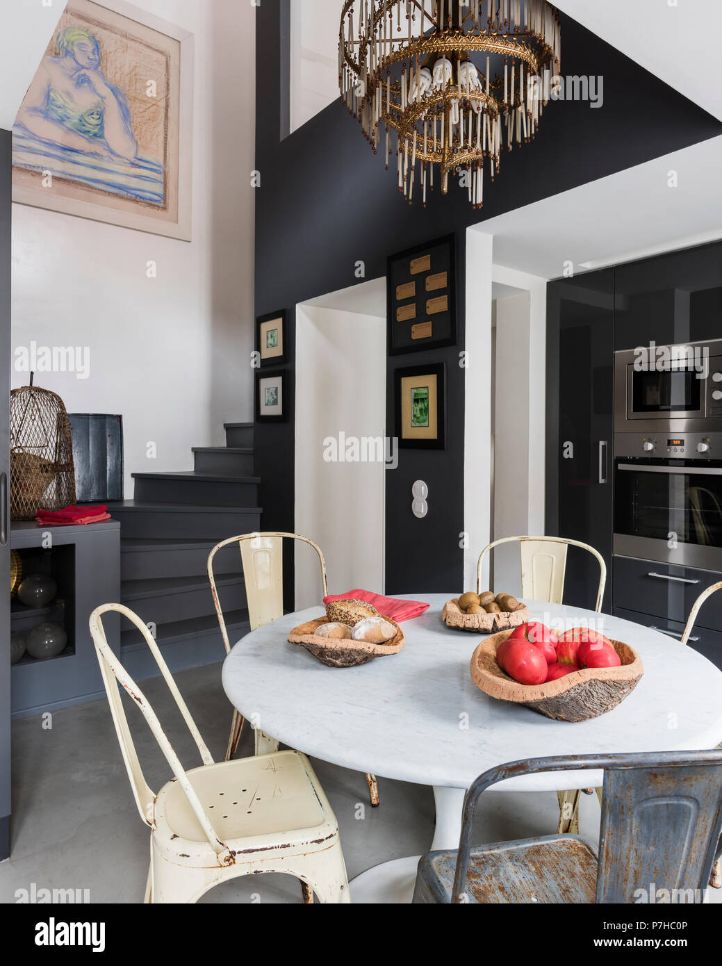 Essbereich in moderne offene Apartment mit Vintage metall Tolix Stühle und runde Marmorplatte Tabelle Stockfoto