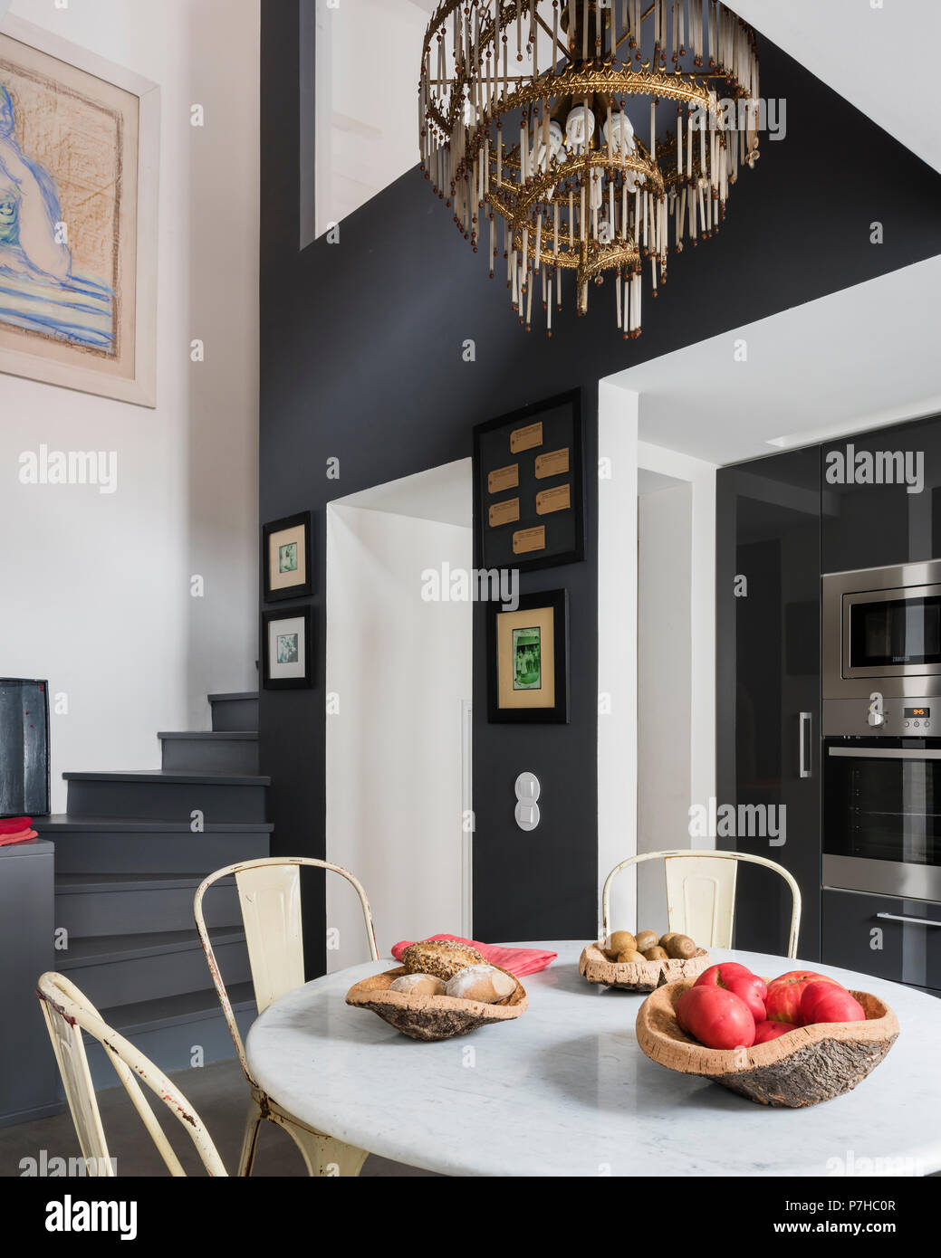 Essbereich in moderne offene Apartment mit Vintage metall Tolix Stühle und runde Marmorplatte Tabelle Stockfoto