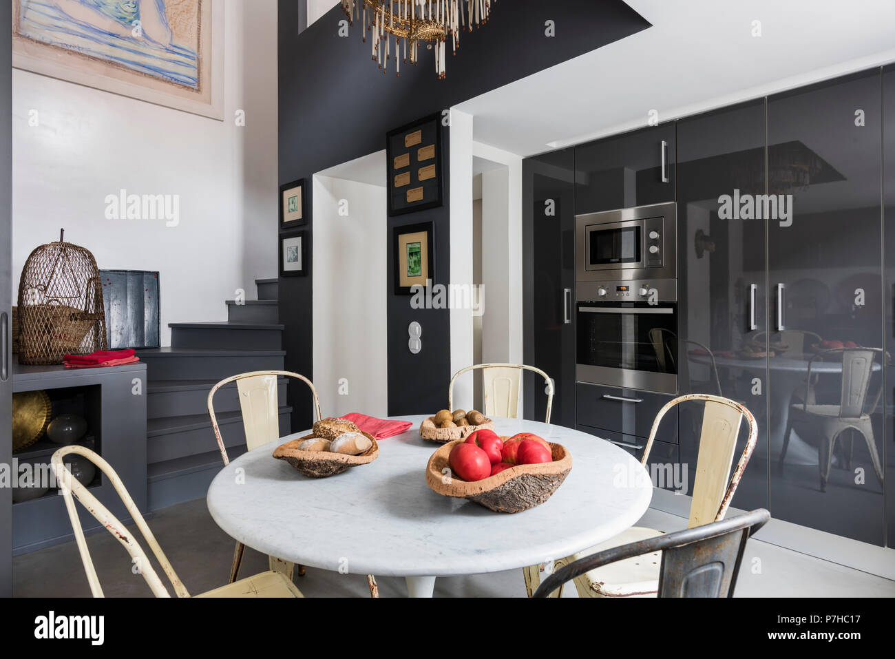 Essbereich in moderne offene Apartment mit Vintage metall Tolix Stühle und runde Marmorplatte Tabelle Stockfoto