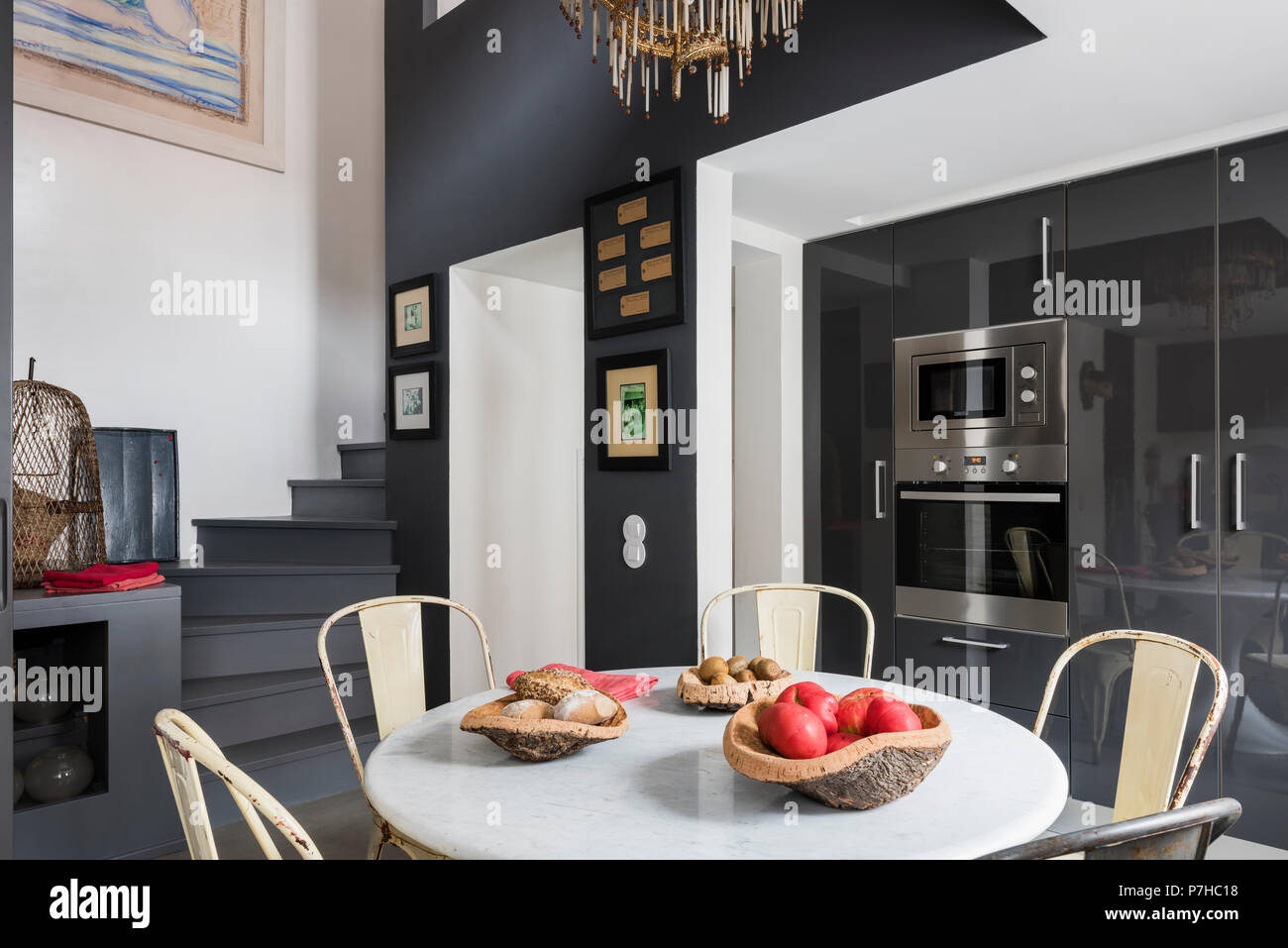 Essbereich in moderne offene Apartment mit Vintage metall Tolix Stühle und runde Marmorplatte Tabelle Stockfoto