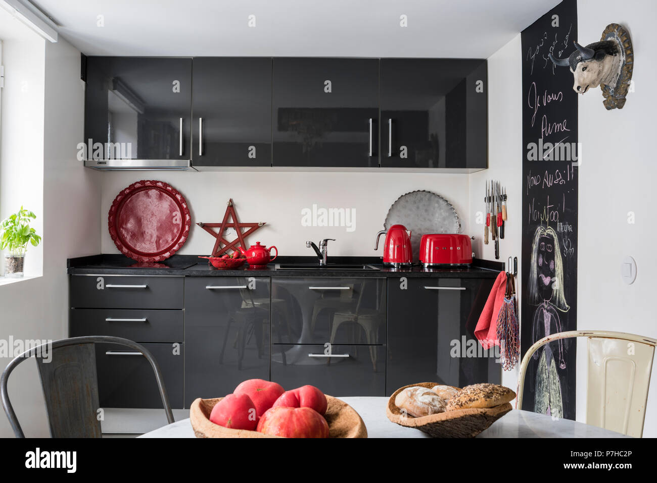 Dunkelgrau Flachbild fronted Küchen in der modernen Küche mit Vintage tolix Metall Stühle Stockfoto