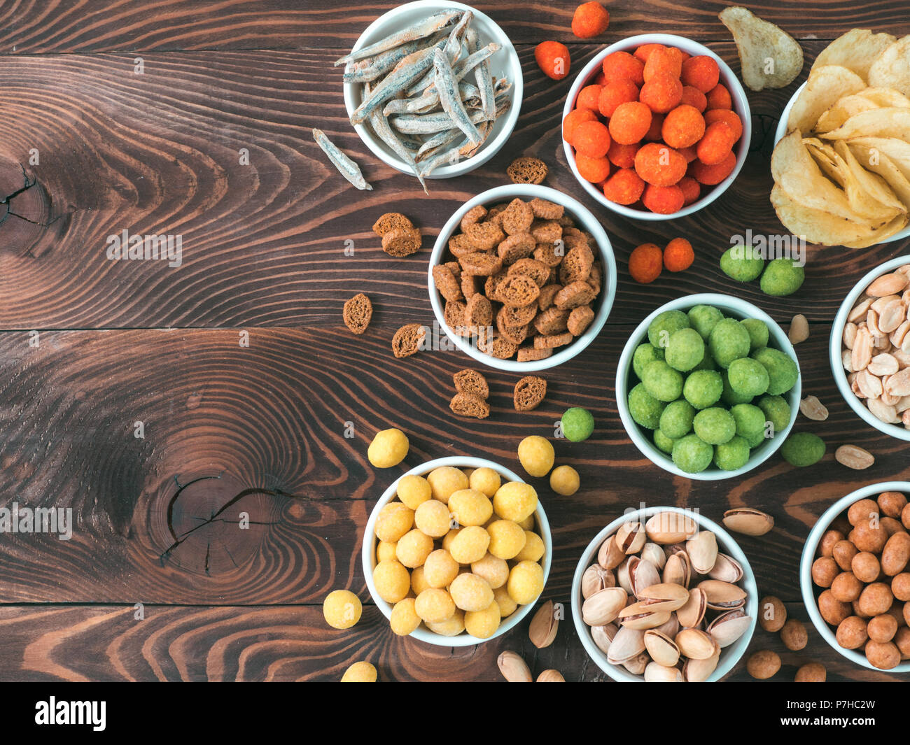 Sortiment von verschiedenen Snack für Bier, Wein, Party. Erdnüsse in Coconut Glasur, grüne vasabi, rote scharfe Chili, gelben Käse Glasur, Chips, Pistazie, Stockfoto