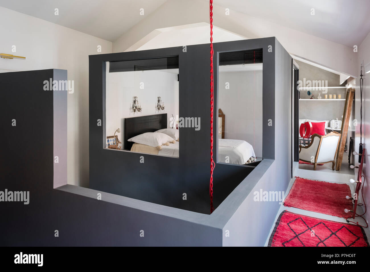 Im Schlafbereich im Loft - modernes Apartment mit Rot marokkanische Teppiche Boxed Stockfoto