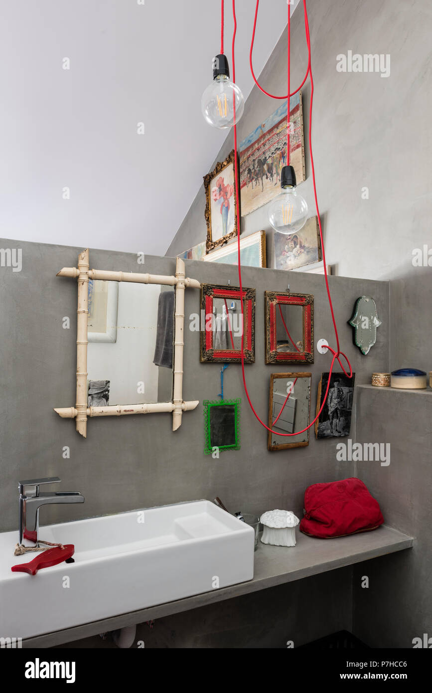 Eine Auswahl an kleinen vintage Spiegel im Badezimmer des Loft Apartment mit roter Beleuchtung Kabel Stockfoto