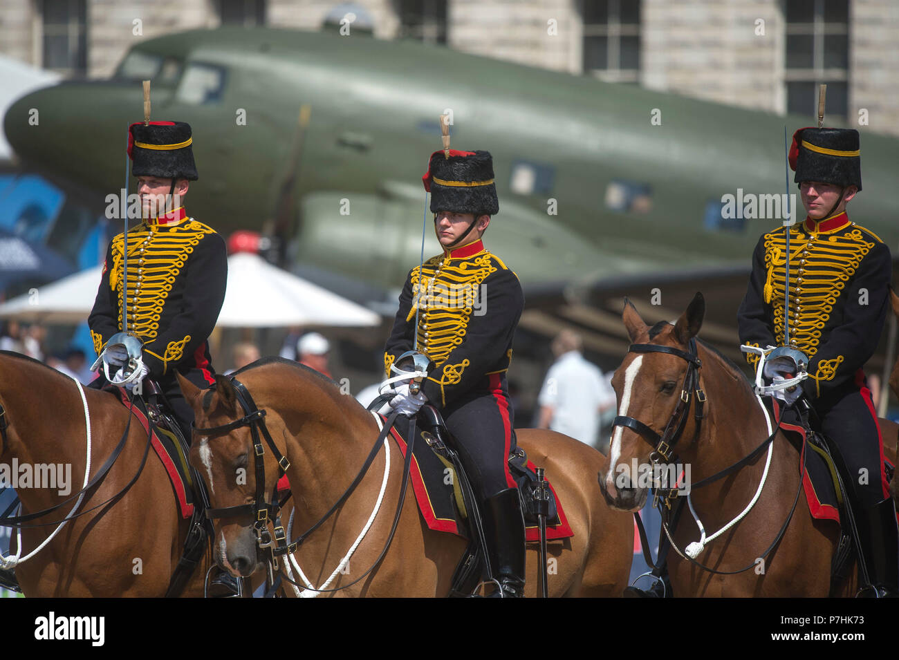 Mitglieder der King's Troop, Royal Horse artillery, nehmen teil an der den Wachwechsel Zeremonie vor einem Douglas Dakotaon, auf Horse Guards Parade, London, als historische Flugzeuge sind als Teil der nationalen Flugzeuge Tour angezeigt zu 100 Jahren der Royal Air Force. Stockfoto