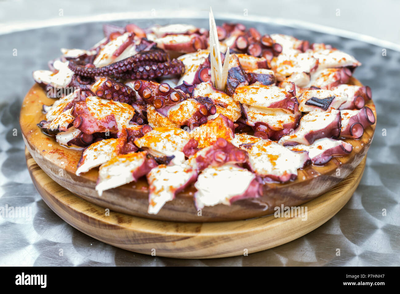 Holzplatte der galizischen Stil gekochten Tintenfisch mit Paprika und Olivenöl. Pulpo a la gallega Stockfoto