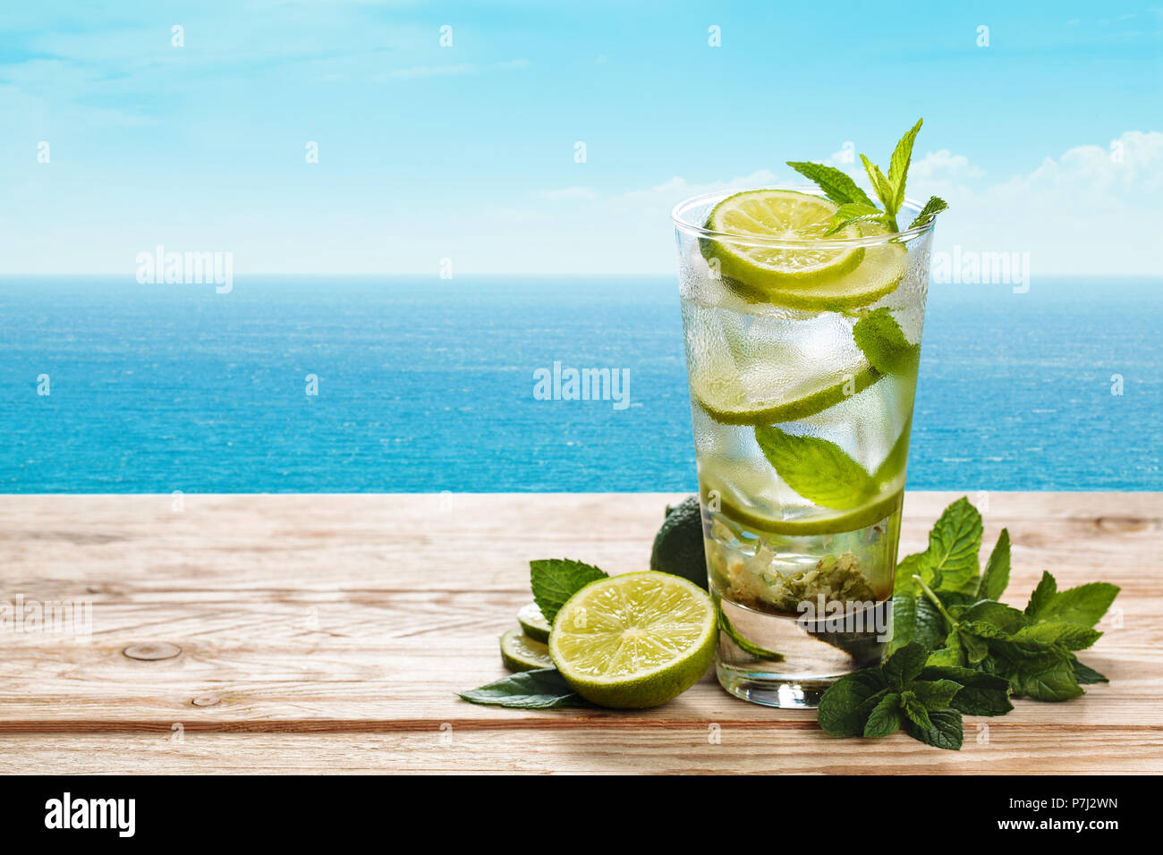 Frischen mojito Cocktail auf Blau rustikal Tisch mit blauen Meer im Hintergrund. Stockfoto