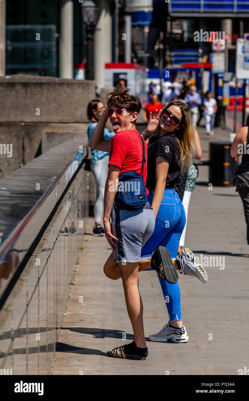 Zwei junge Menschen posieren für die Kamera auf die London Bridge, London, England Stockfoto