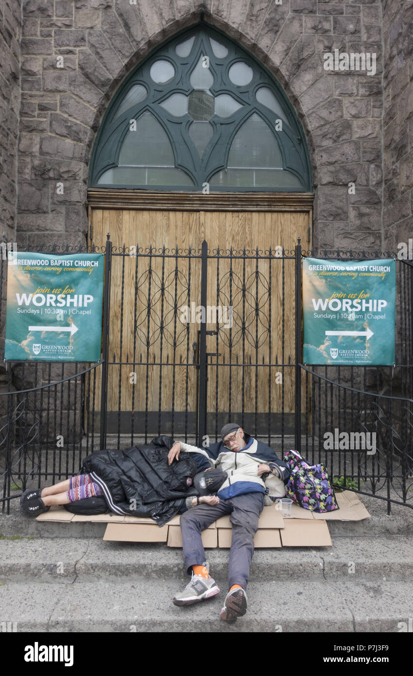 Mann und Frau schlafen tief und fest in den frühen Morgenstunden vor einer baptistischen Kirche entlang der 7. Avenue in Park Slope, Brooklyn, New York. Stockfoto