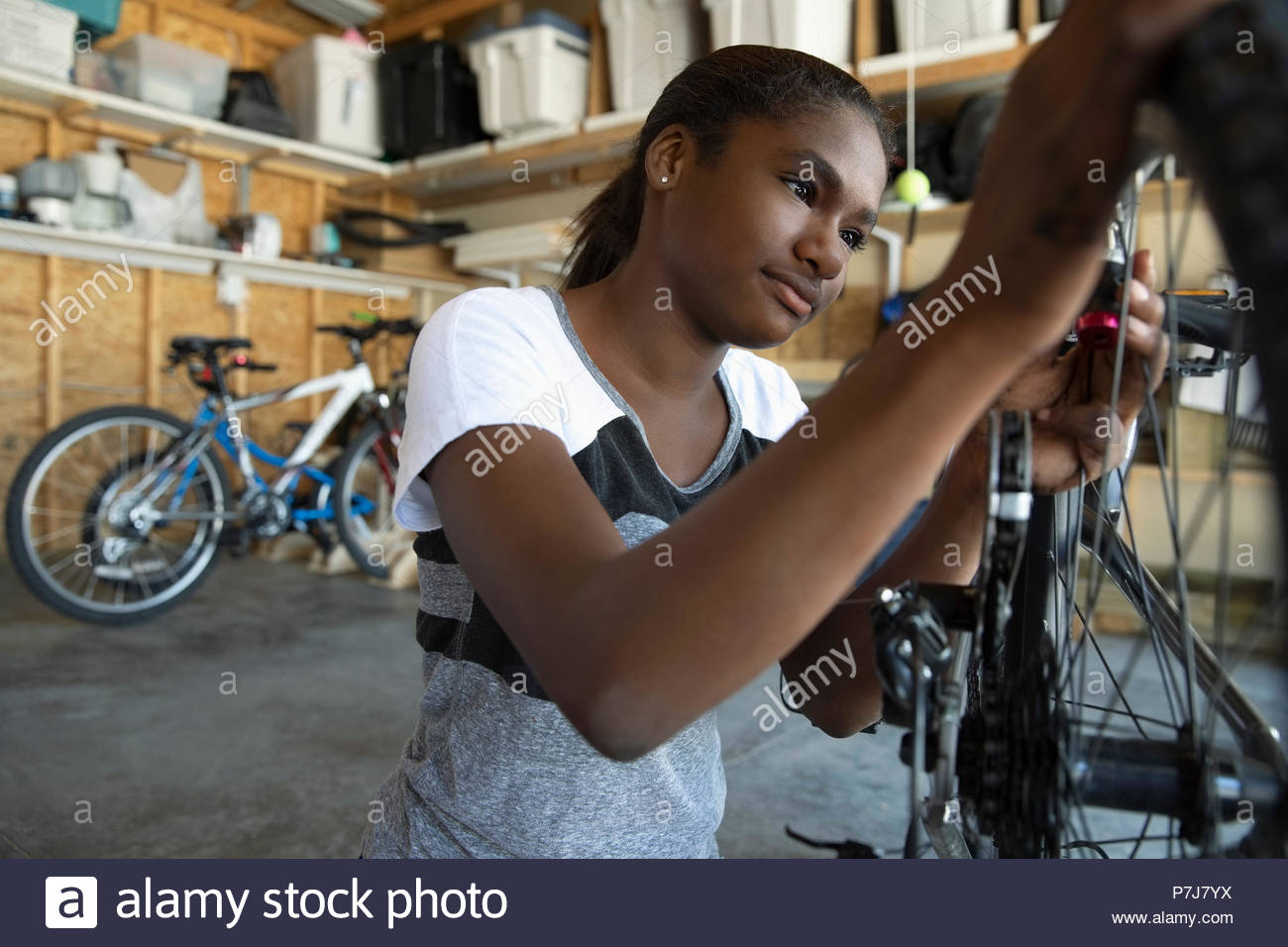 Tween girl Fahrrad zur Festsetzung in einer Garage. Stockfoto