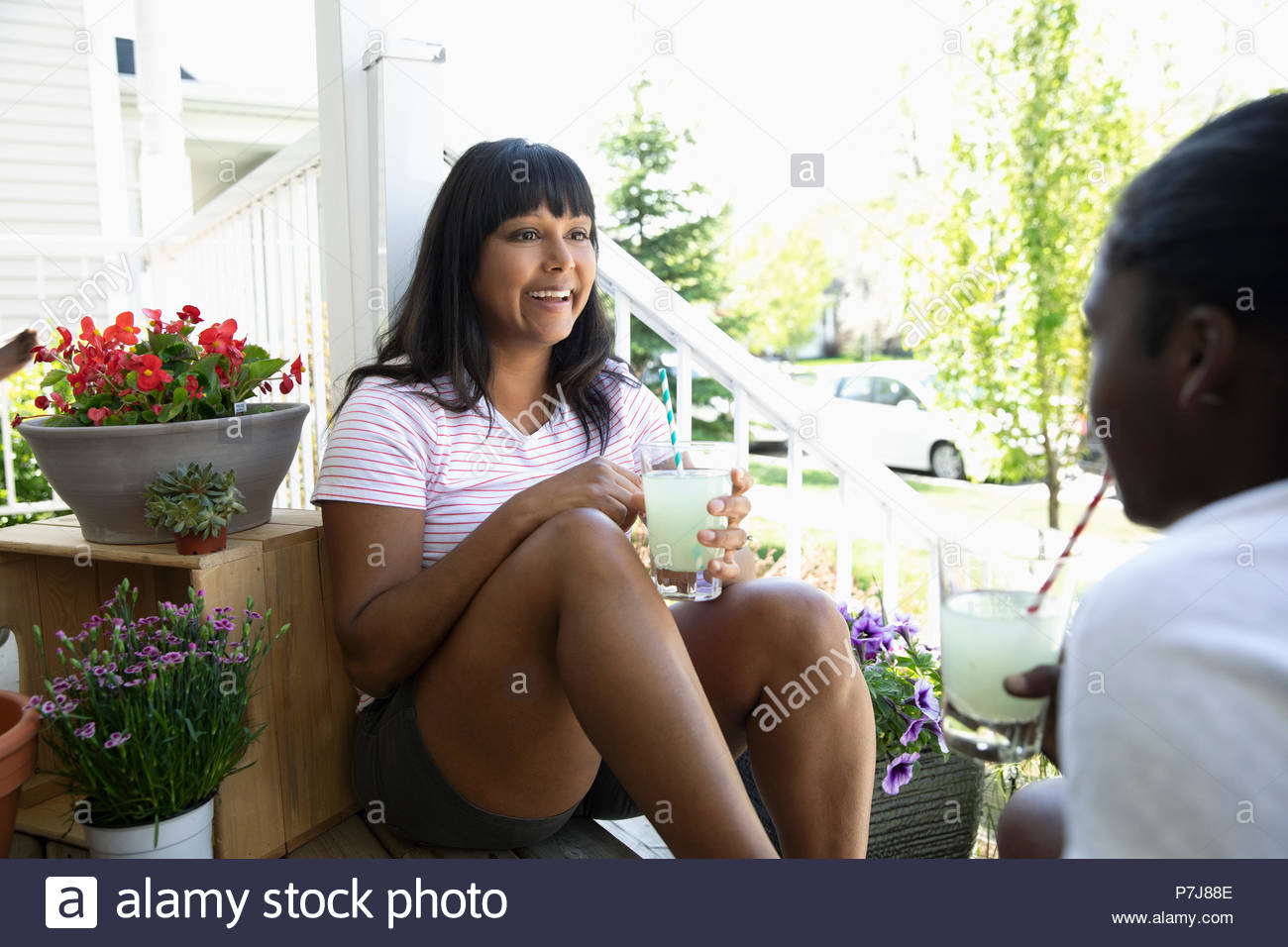 Mutter und Tochter Bonding, trinken Limonade und sprechen auf der Vorderseite stoop Stockfoto