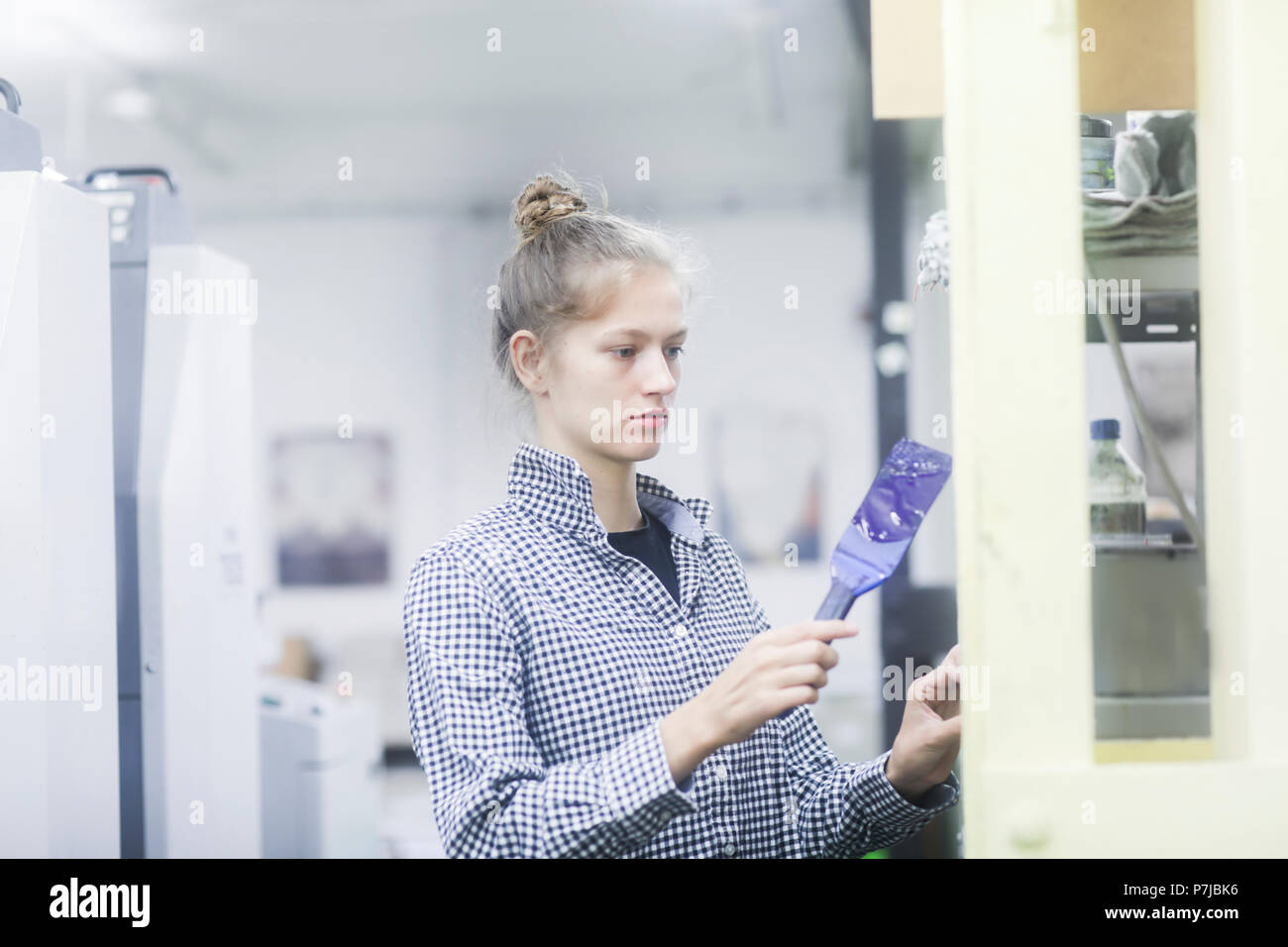 Frau mischen Druckfarbe in der Druckmaschine Stockfoto