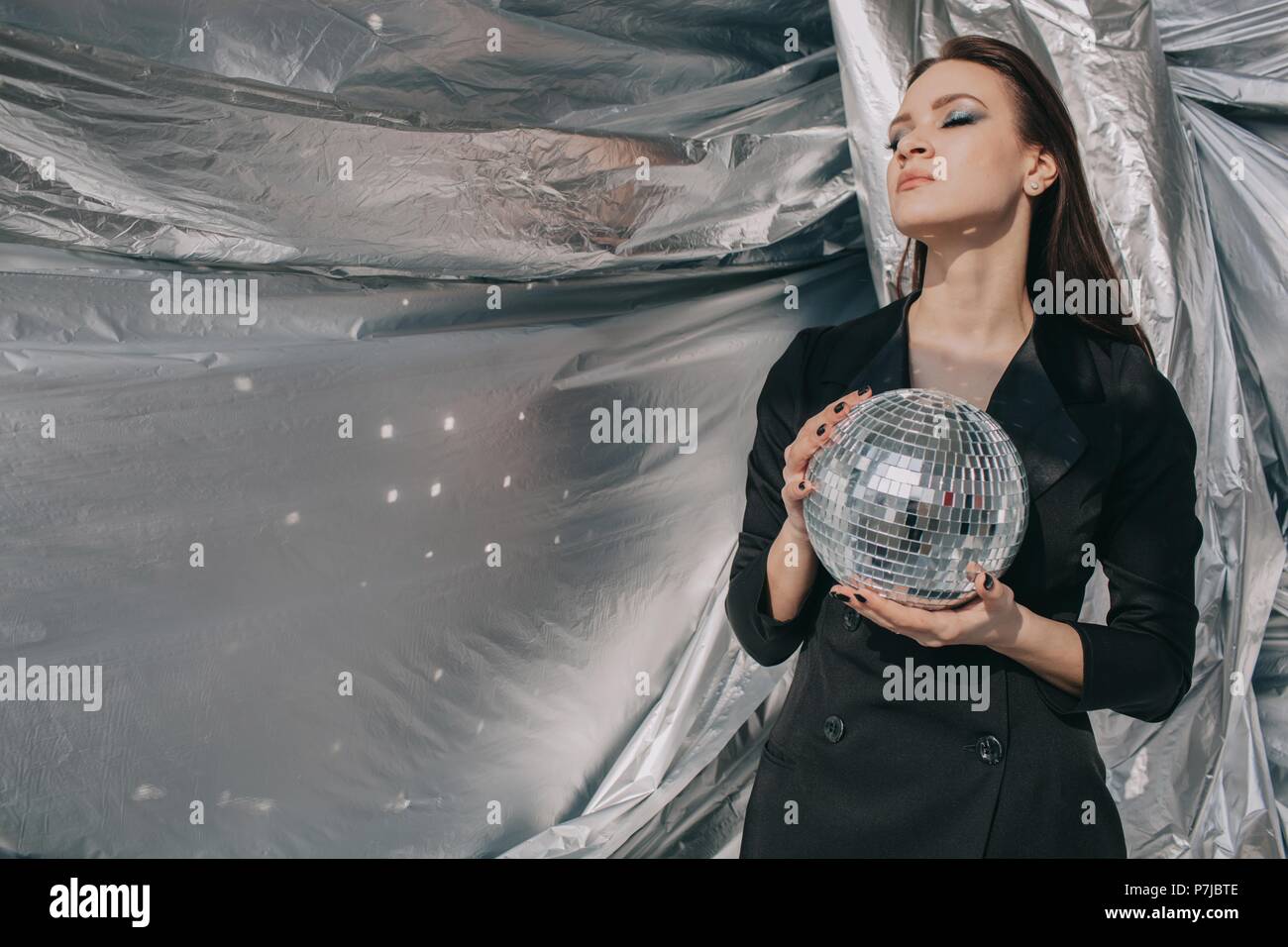 Portrait von einer Frau mit einem silbernen Disco ball Stockfoto